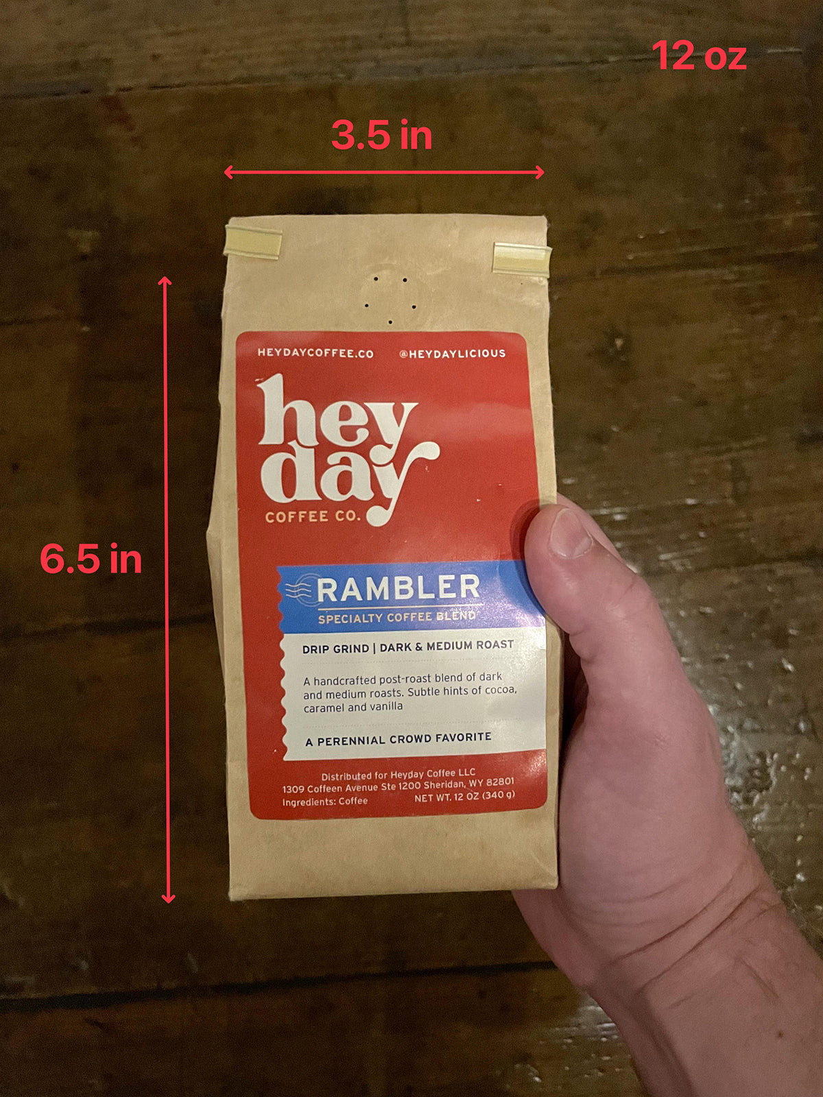 Heyday Coffee Co. coffee package held by a hand above a wooden surface with annotated measurements