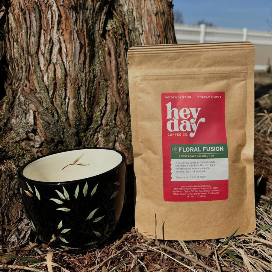 Floral Fusion tea pouch with a black and white patterned cup against a tree background.